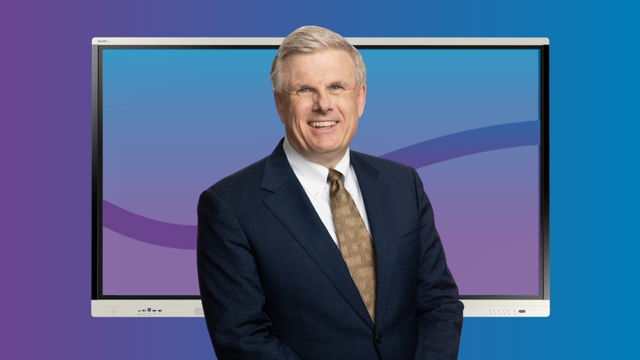 SMART’s CEO, Nicholas Svensson, standing in front of a SMART interactive display and a blue/purple background.